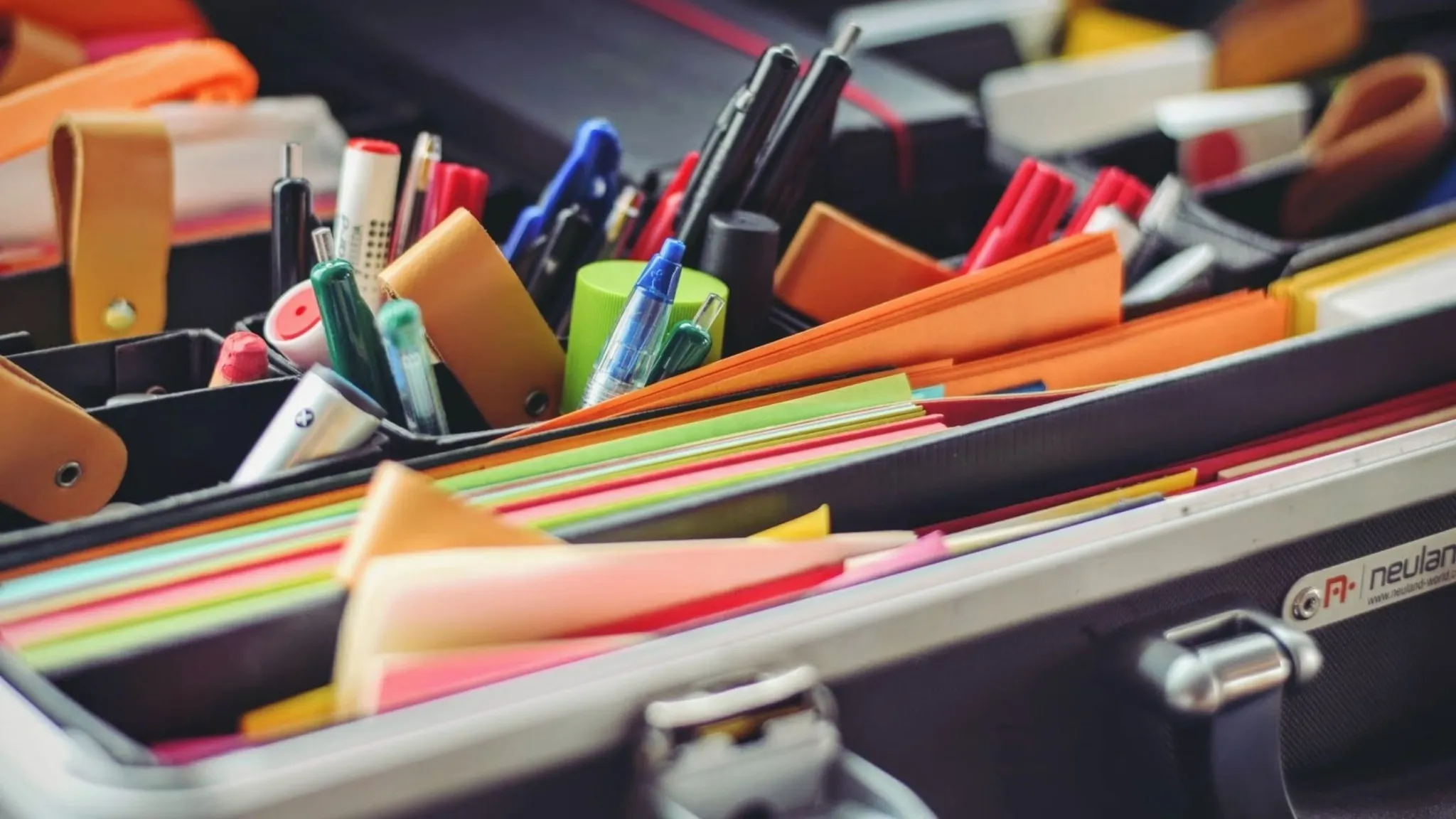 Organized office supplies including notebooks, pens, and a stacks of paper