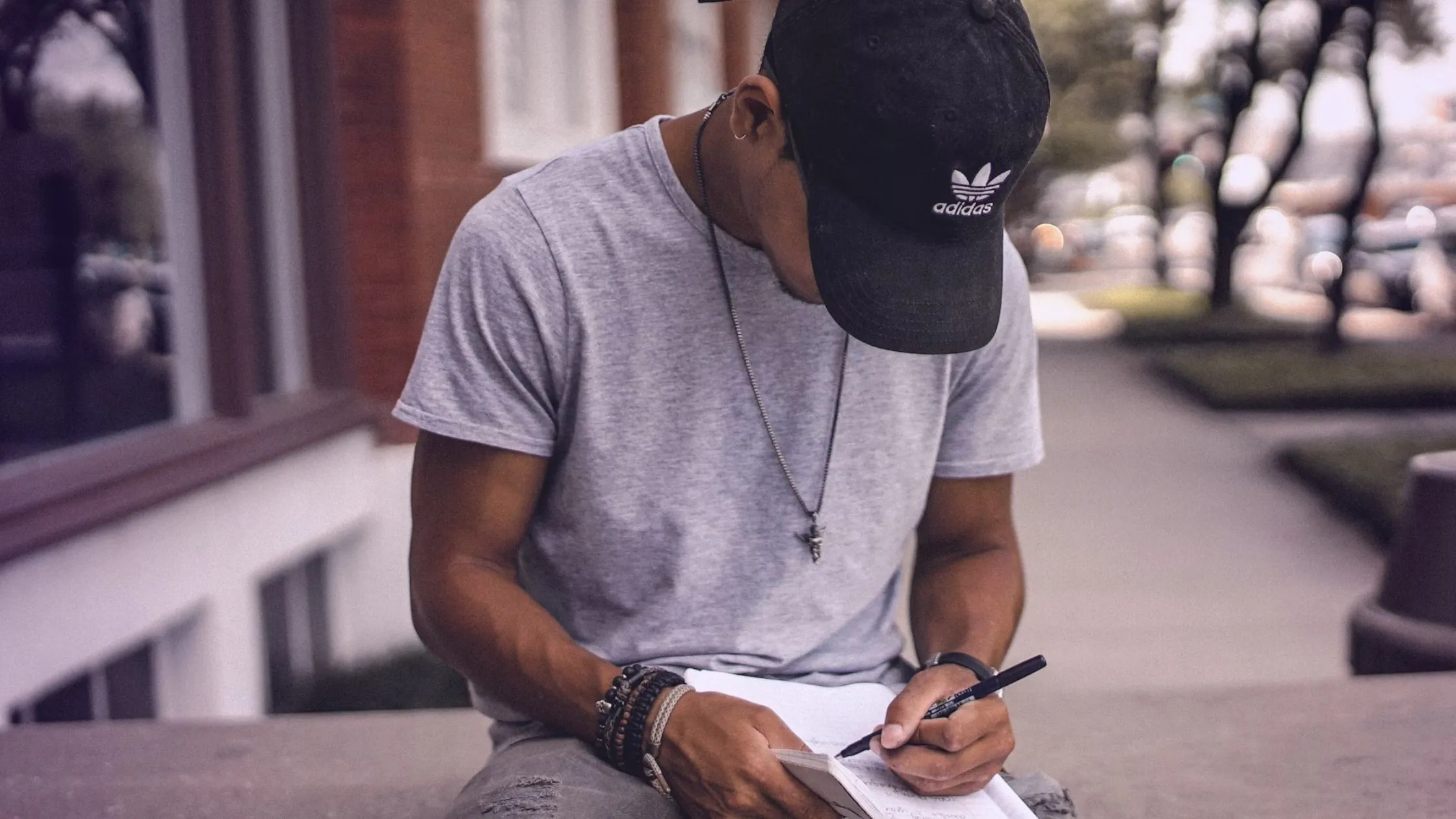 Person wearing hat writing on paper